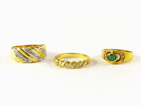 Three yellow and white gold rings with oval emerald and diamonds