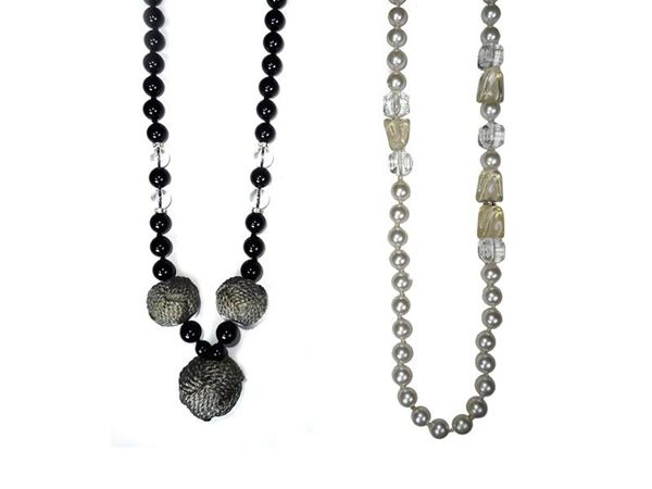 Due collane in perle di resina nera e trasparente