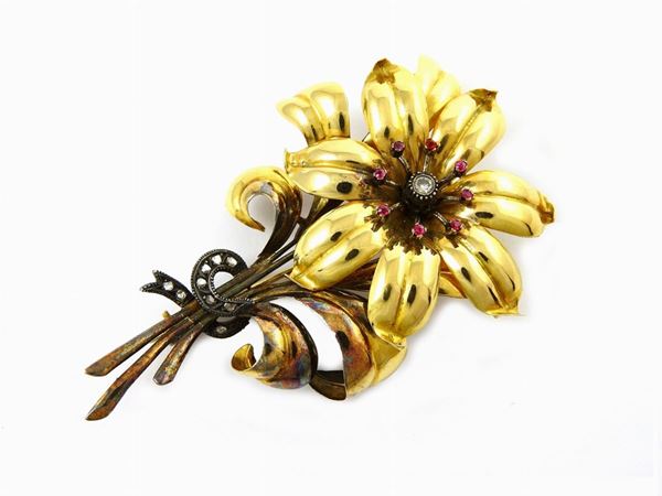 Yellow gold and silver flower shaped brooch set with diamonds and syntethic rubies