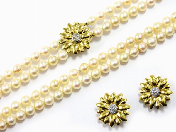 Parure of two strands pearl necklace with clasp and yellow gold floral motiv earclips with diamonds
