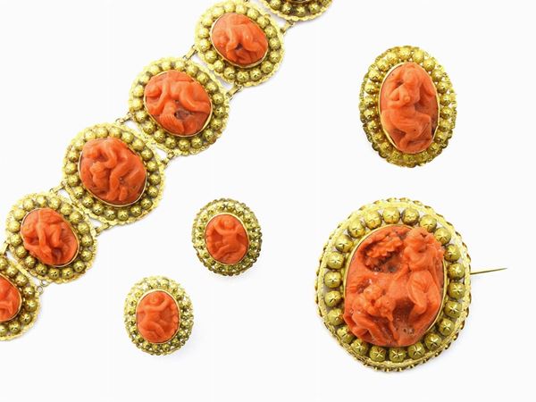 Parure of yellow gold bracelet, earrings and two brooches set with red coral high relief cameos