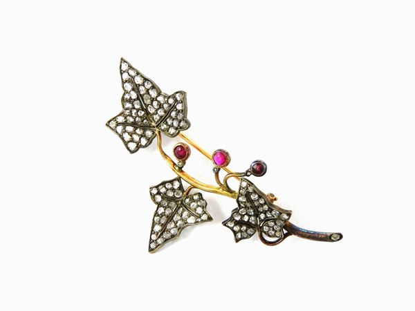 Yellow gold and silver brooch set with diamonds and rubies realized as an ivy branch