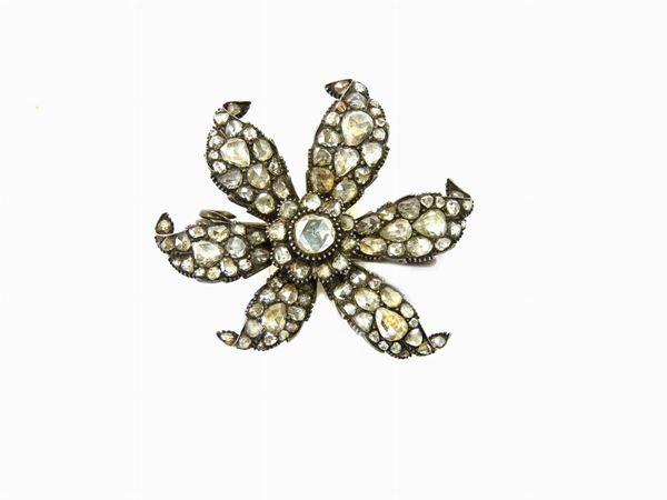 Silver flower shaped brooch with diamonds