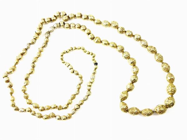Long necklace of low alloyed yellow gold empty embossed beads