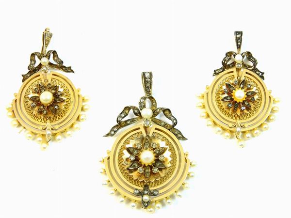 Set di tre medaglioni pendenti in oro giallo, argento, diamanti e perle