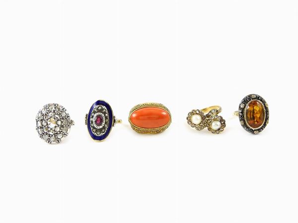 Cinque anelli in oro giallo, argento, smalto, diamanti, perle, rubino, corallo e quarzo citrino