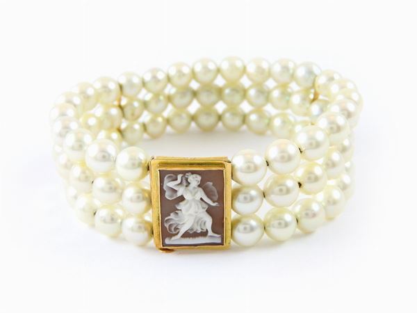 Three strands Akoya pearls semi rigid bracelet with yellow gold and seashell cameo clasp