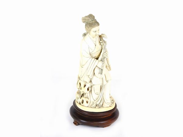 A Carved Ivory Figure of a Musician