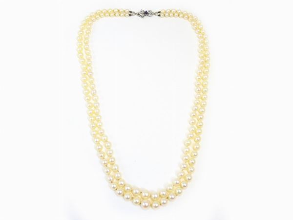 Two graduated pearls strands necklace with white gold clasp set with diamonds and sapphires
