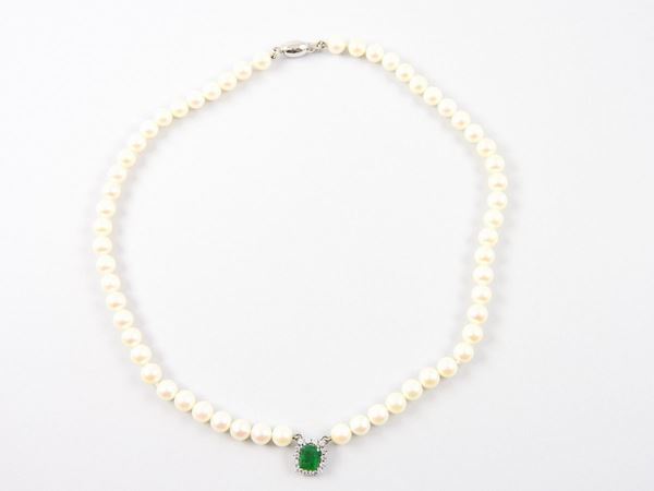 Akoya cultured pearls necklace with white gold central ornament set with diamonds and emerald
