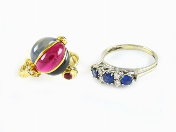 Un anello in oro giallo e pietre artificiali e uno in oro bianco, diamanti e zaffiri