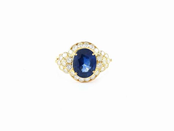 Yellow gold ring with diamonds and oval cut sapphire