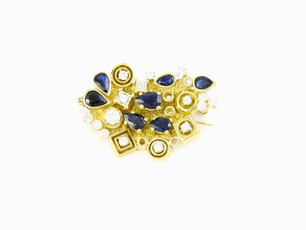 Yellow gold design brooch with diamonds and sapphires