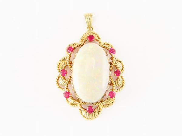 Yellow gold pendant with big Australian precious opal and red stones