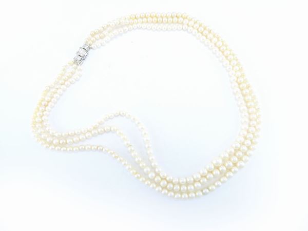 Three graduated strands Akoya pearls necklace with platinum clasp set with diamonds