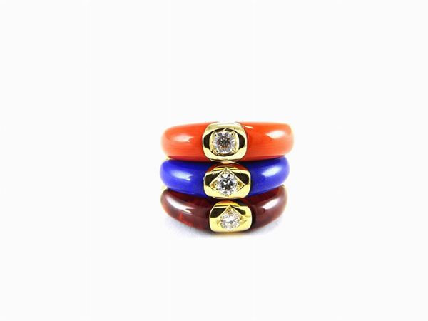 Three yellow gold rings with diamonds, coral, lapis lazuli and brownish stone