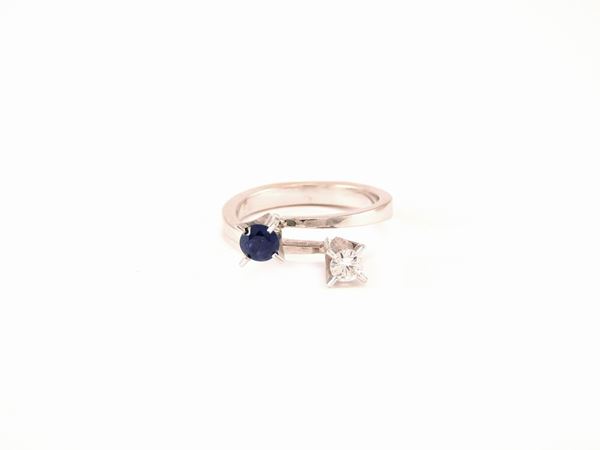 White gold croisé ring with diamond and sapphire