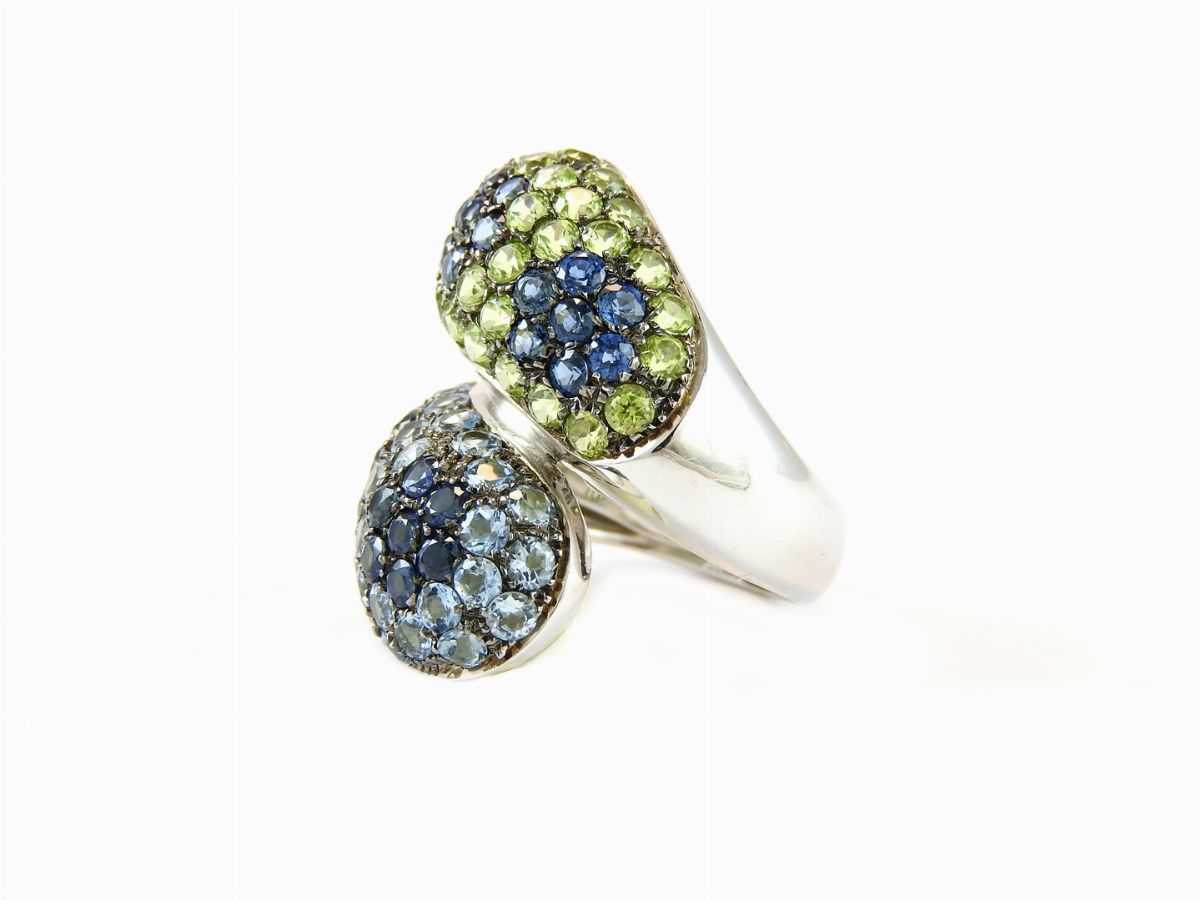Anello Contrarié in Oro Bianco, Zaffiri, Acquemarine e Peridoti