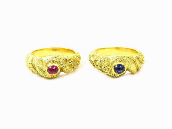 Coppia di anelli in oro satinato giallo, rubino e zaffiro