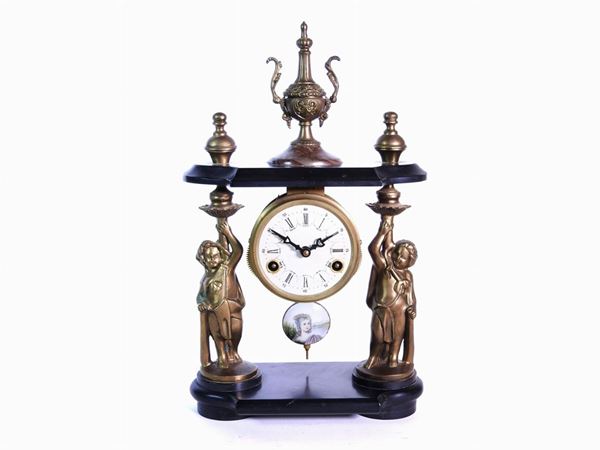 A Gilded Metal and Black Marble Mantle Clock