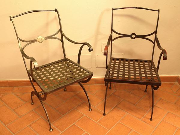A group of three wrought iron armchairs