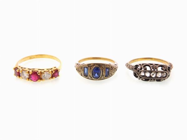 Three yellow and white gold and silver rings with diamonds, rubies and blue stones