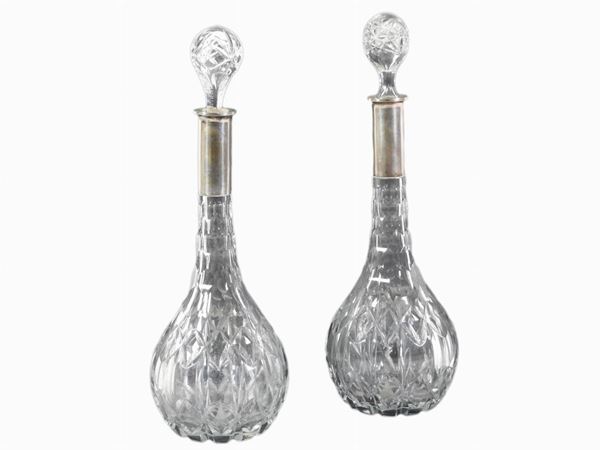 A pair of crystal and silver wine bottles