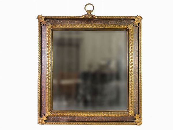 A gilted metal and painted wooden mirror