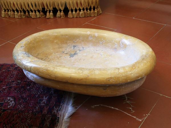 A large oval yellow Siena marble font