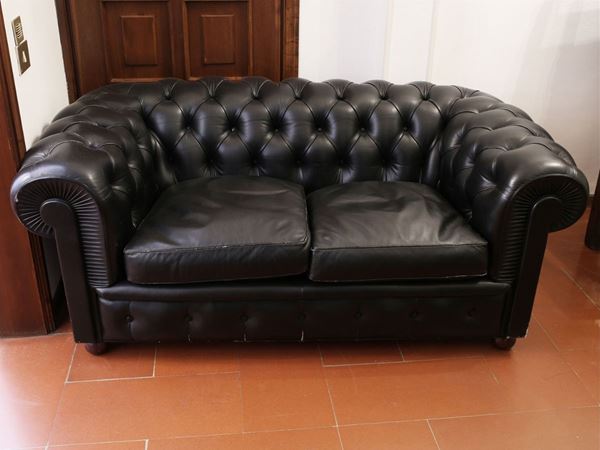 A black leather Chesterfield sofa