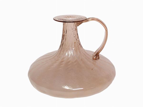 A blown glass vase with applied handle