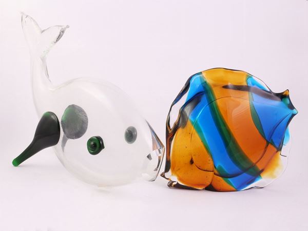 A three coloured glass fish and one transparent  glass fish with green applications