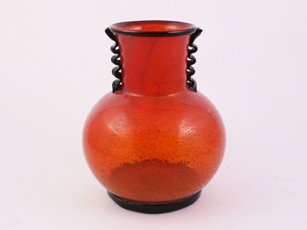 A red glass vase with silver inclusions and snake-shaped handles