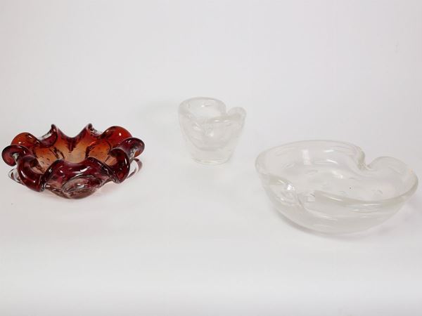 Two iridiscent clear ashtrays with bubbles and a red glass ashtray with bubbles