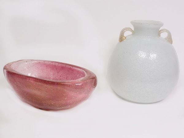 Un vaso in vetro con manici e una ciotola rosa
