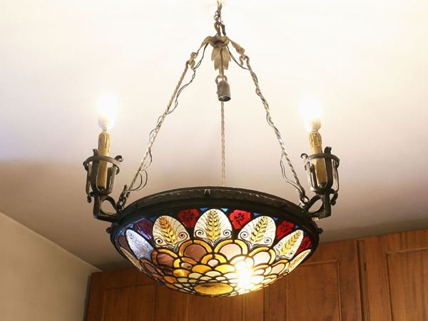 A wrougth iron and coloured glass chandelier