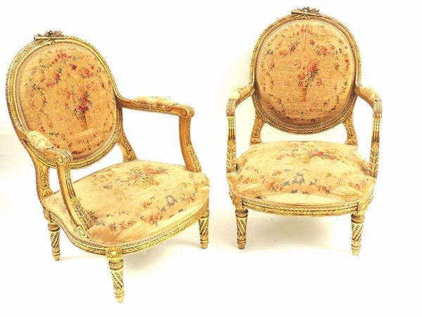 A pair of gilted and curved armchairs