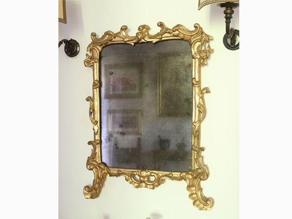 A small gilted and curved wooden mirror