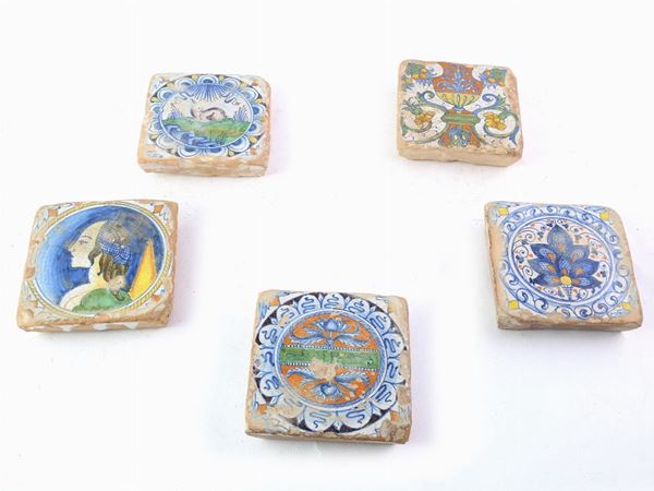 A collection of five glazed terracotta tiles