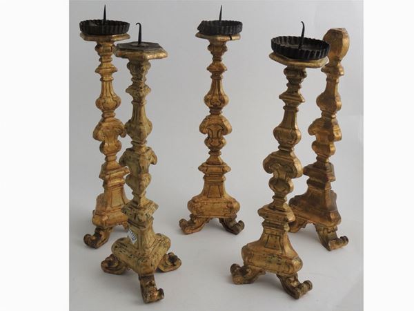 Serie di cinque torciere in legno intagliato e dorato