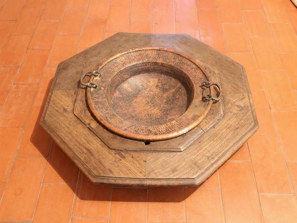 A copper brazier on wooden base