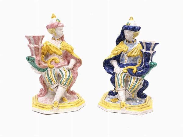 A glazed and painted terracotta pair of candlesticks