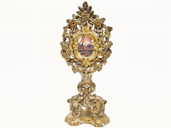 A gilted and curved wooden reliquary
