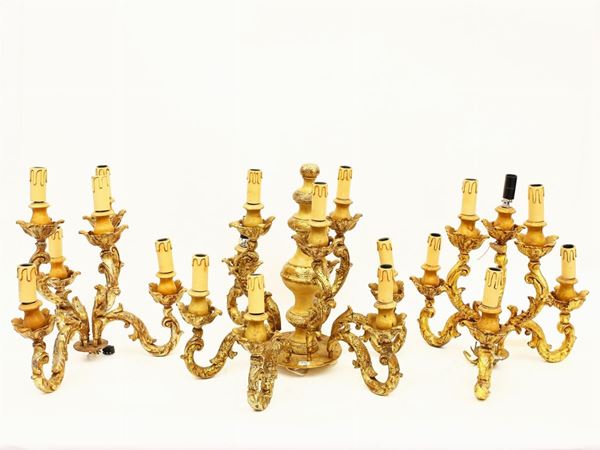 Serie di tre flambeaux da tavolo in legno intagliato e dorato