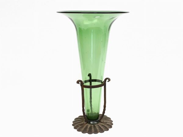 A large green blown glass and wrougth iron vase