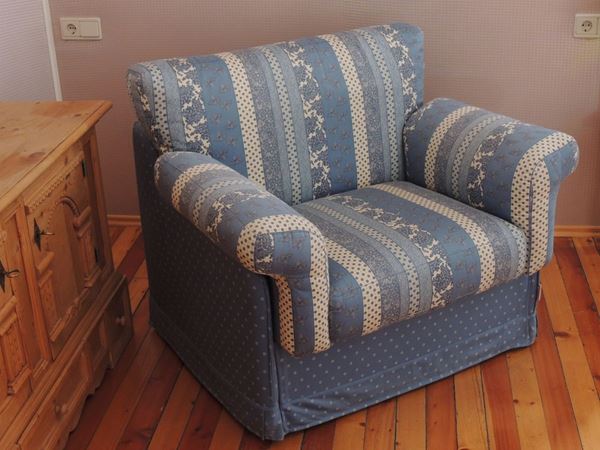 An upholstered armchair bed