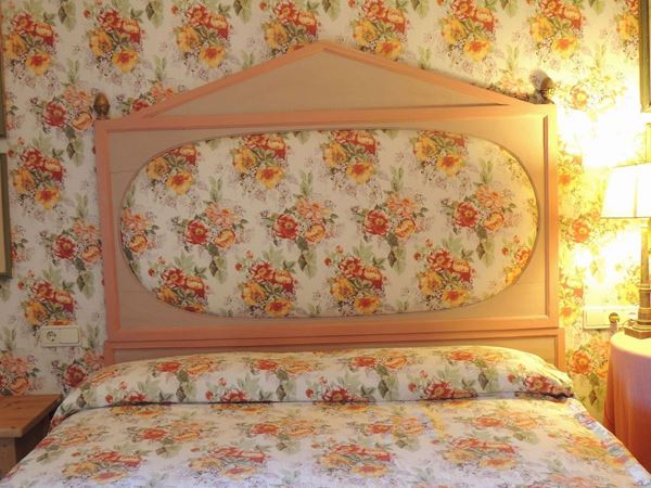A double bed pink painted wooden headboard