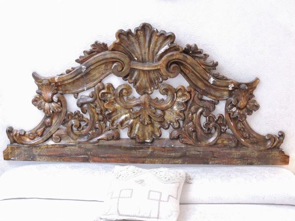 A giltwood and carved headboard