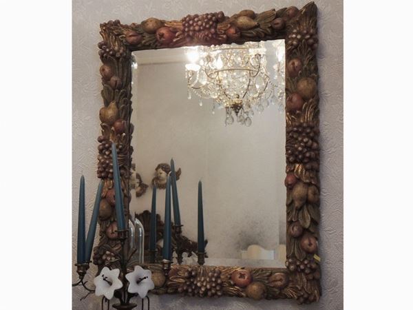A mirror with carved wooden frame