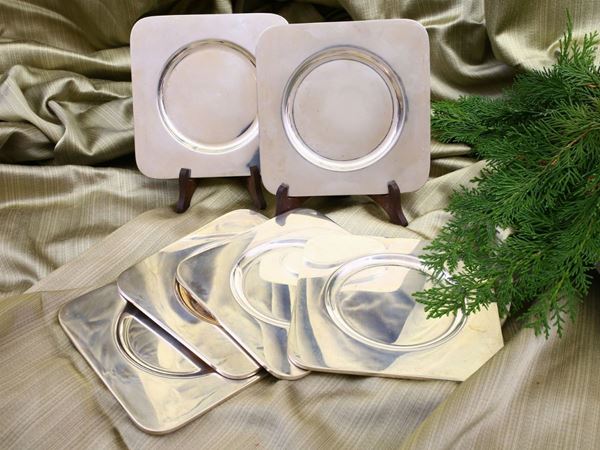 A set of fourteen silver bread plates
